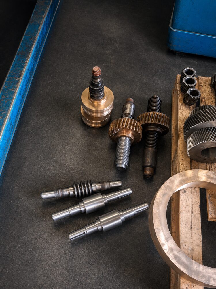 Shafts, gears and bronze components staged for machining